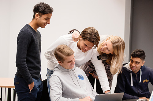 Grupp ungdomar framför en dator